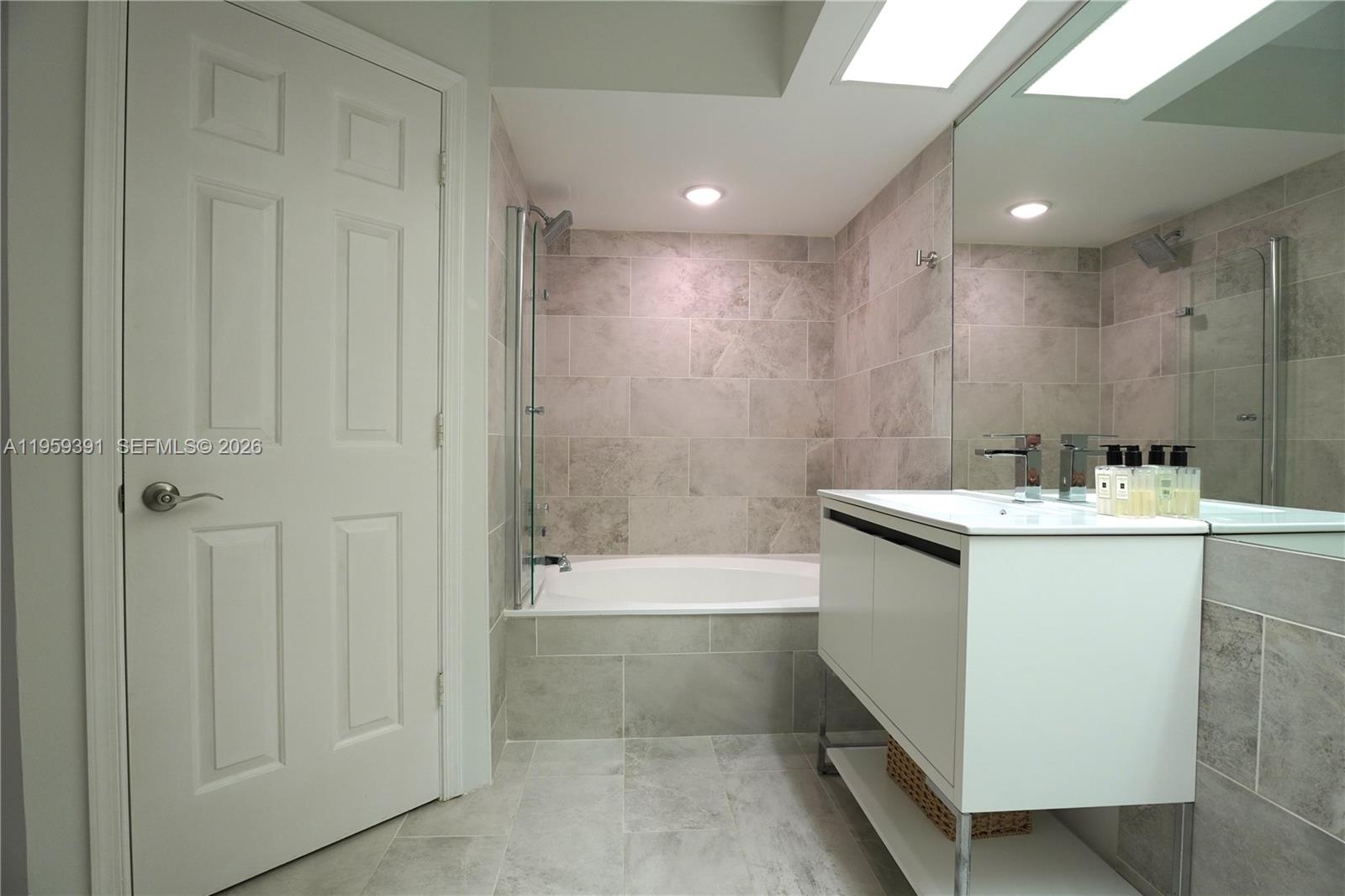 5741 Coach House Circle, Unit H Boca Raton, FL 33486 - Photo 16 of 34 a bathroom with a bathtub a sink and a shower