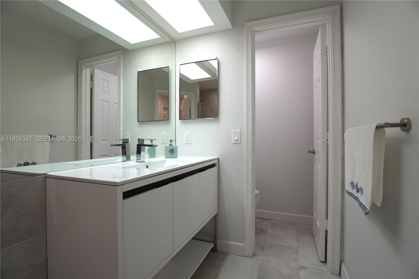 5741 Coach House Circle, Unit H Boca Raton, FL 33486 - Photo 22 of 34 a bathroom with a sink and a mirror