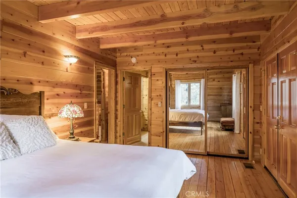 a bedroom with bed and wooden floor