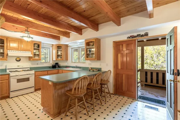 a kitchen with a sink a stove and chairs