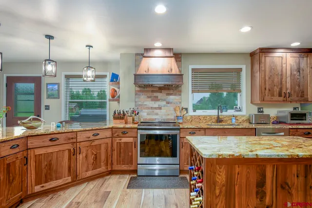 a view of a dining room and livingroom with furniture wooden floor a chandelier