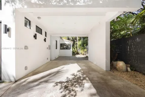 a view of a patio with table and chairs potted plants and large tree