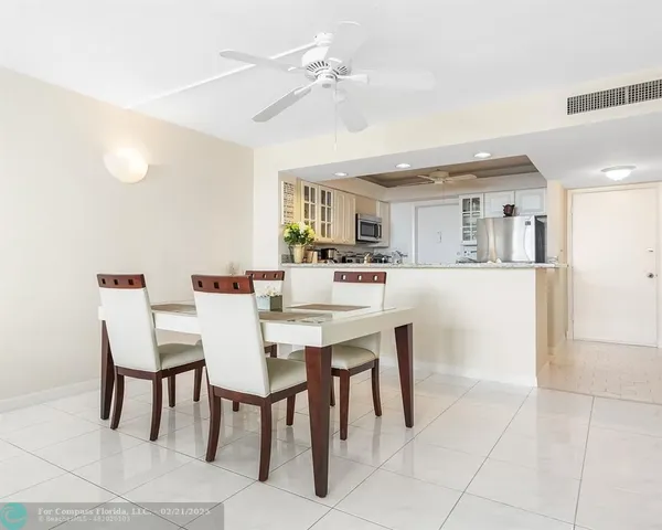 a view of a dining room with furniture and a chandelier fan