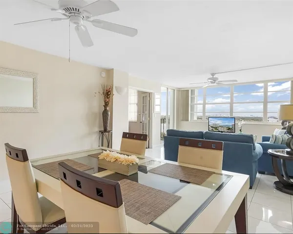 a living room with furniture a large window and a chandelier
