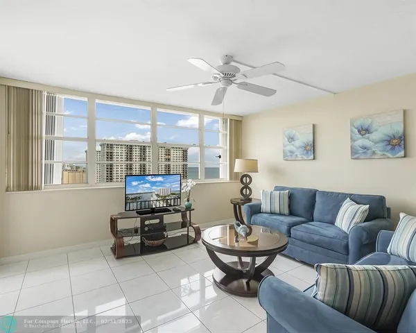 a living room with furniture a view of kitchen and a dining table