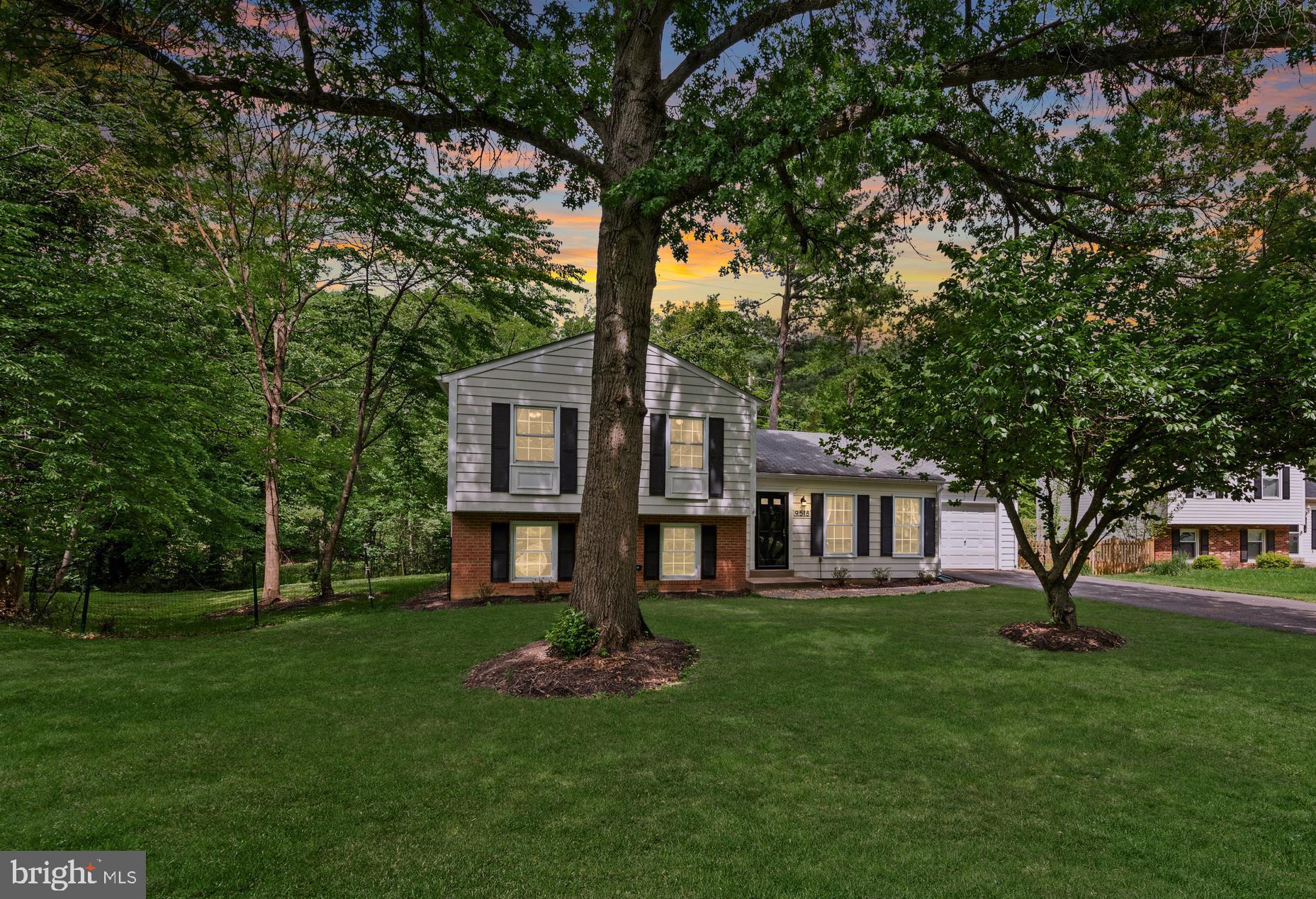 a front view of a house with a yard and trees