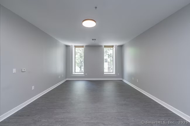 333 State Street, Unit 703 Bridgeport, CT 06604 - Photo 14 of 27 a view of an empty room with a window and wooden floor