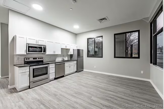 333 State Street, Unit 703 Bridgeport, CT 06604 - Photo 6 of 27 a kitchen with stainless steel appliances granite countertop a stove a sink and a microwave