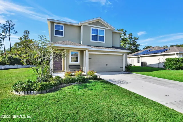 a front view of a house with a yard and garage