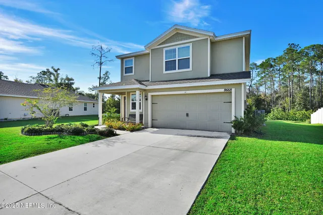 a front view of a house with a yard and garage