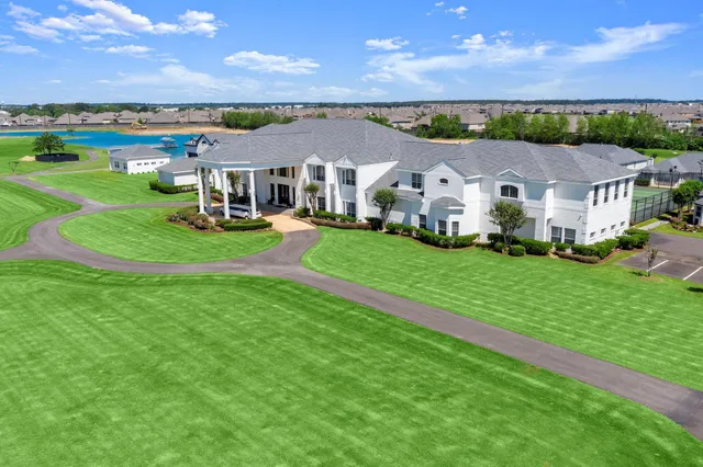 an aerial view of residential houses with outdoor space and trees