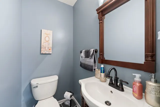a bathroom with a toilet sink and mirror