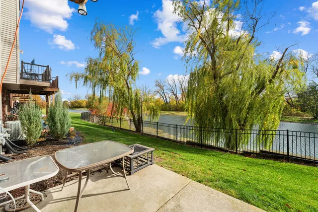 a view of a backyard with table and chairs with wooden fence