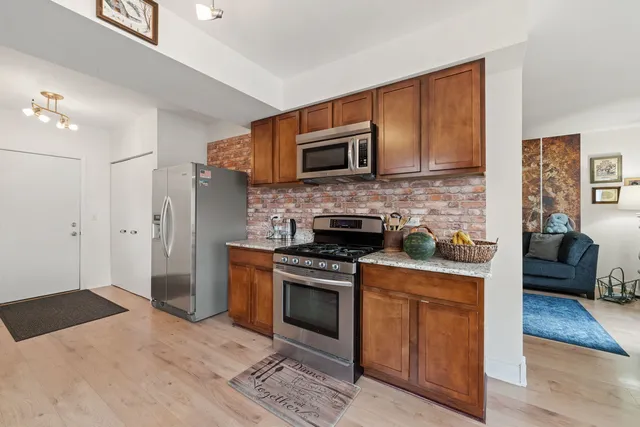 a kitchen with stainless steel appliances granite countertop a stove a sink and a refrigerator