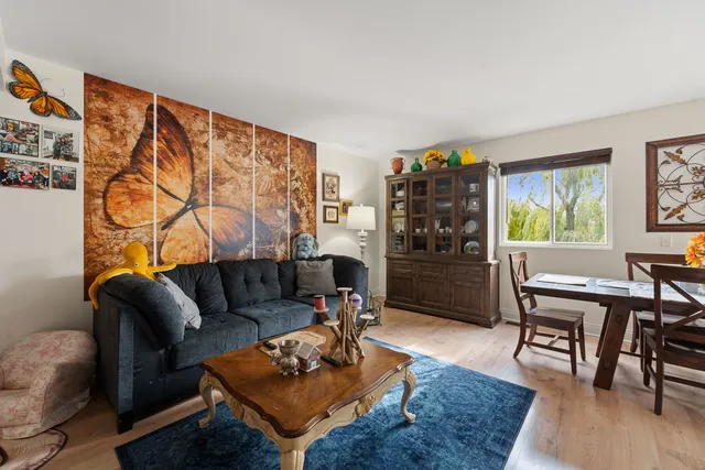 a living room with furniture a rug and a bookshelf