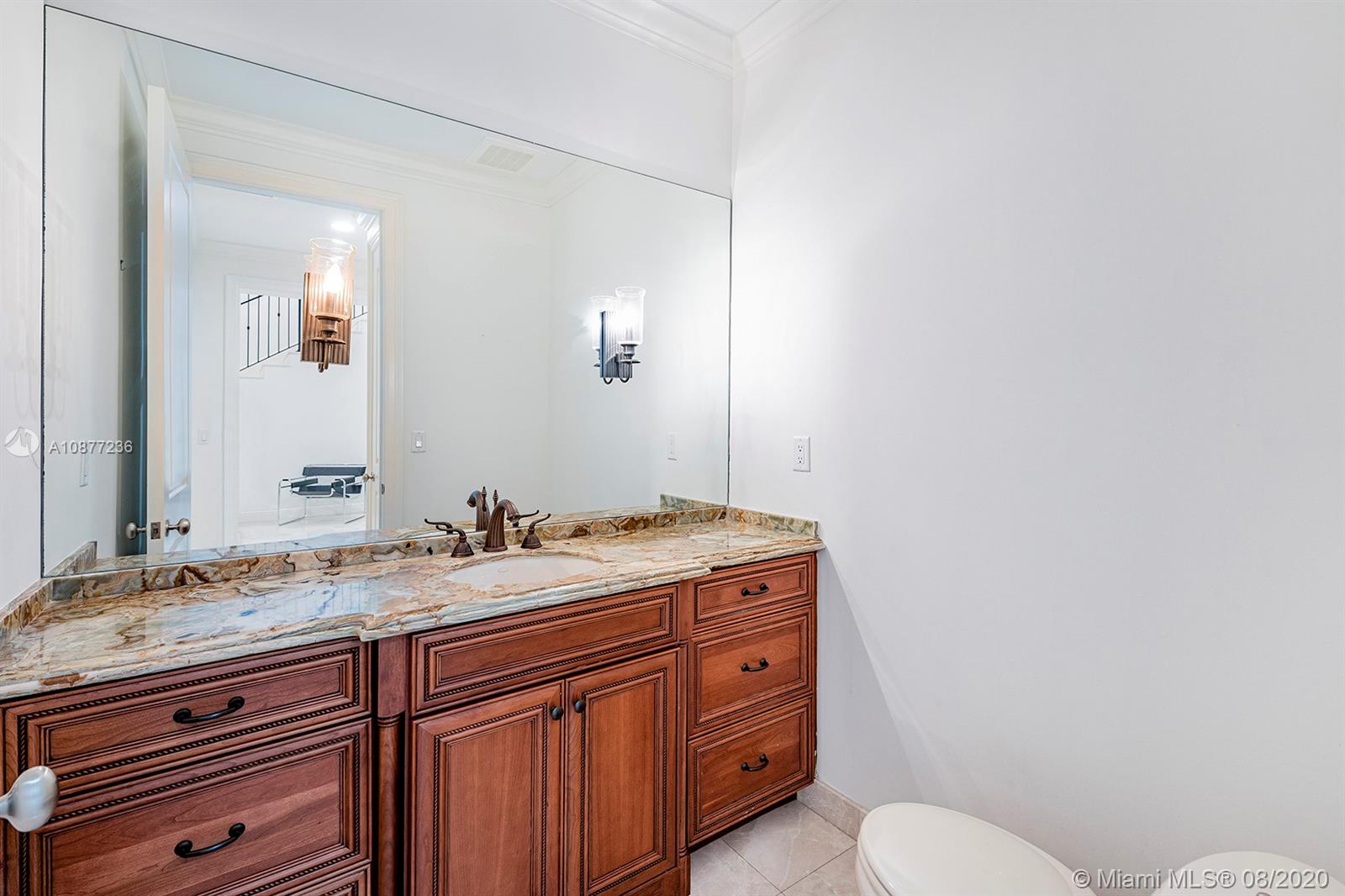 7260 Southwest 119th Street Pinecrest, FL 33156 - Photo 18 of 40 a bathroom with a granite countertop sink mirror vanity and toilet