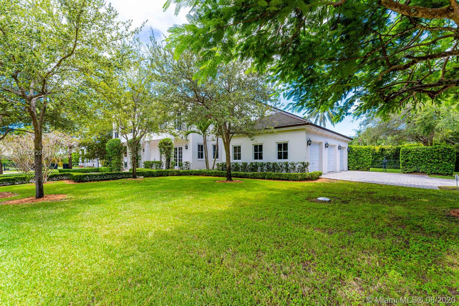 7260 Southwest 119th Street Pinecrest, FL 33156 - Photo 2 of 40 a front view of a house with a garden