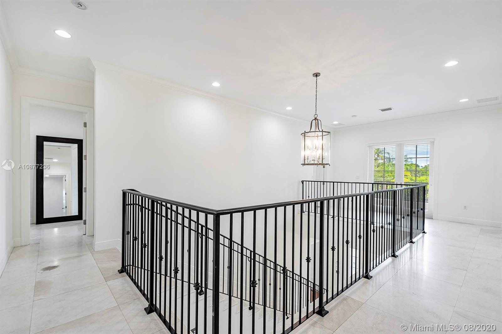 7260 Southwest 119th Street Pinecrest, FL 33156 - Photo 21 of 40 a view of a hallway with wooden floor and windows