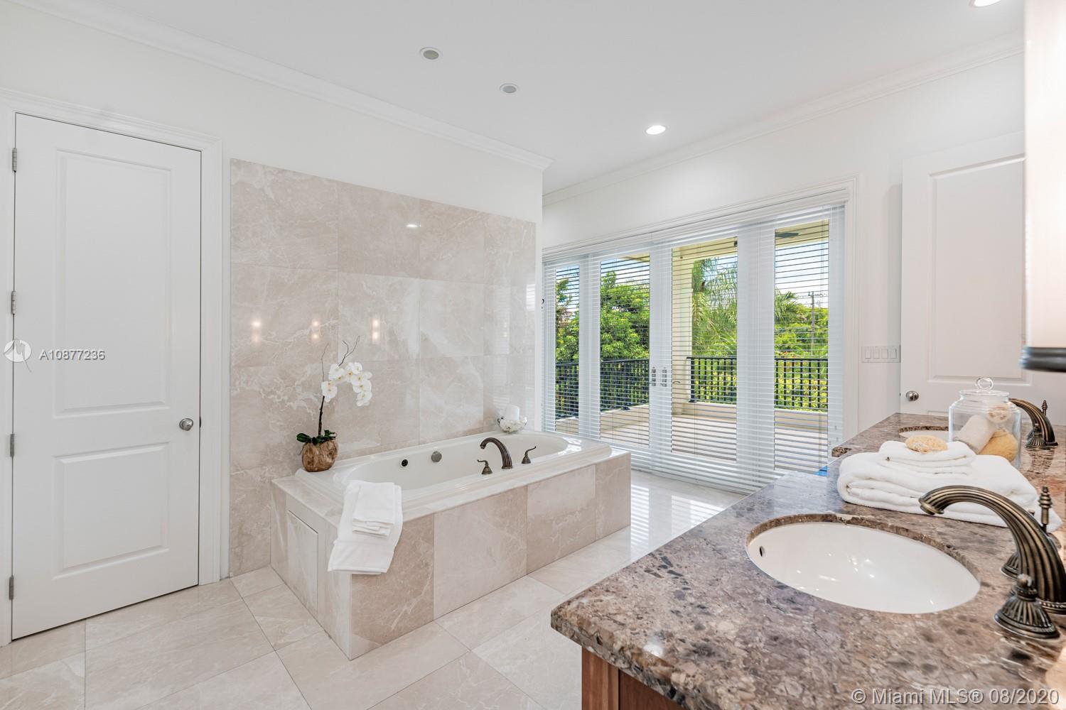 7260 Southwest 119th Street Pinecrest, FL 33156 - Photo 24 of 40 a spacious bathroom with a tub sink and mirror