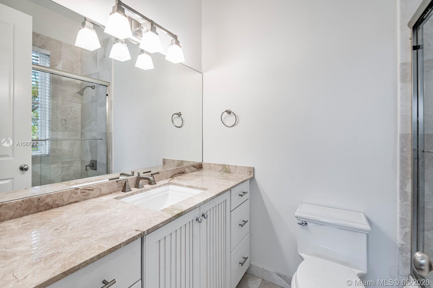 7260 Southwest 119th Street Pinecrest, FL 33156 - Photo 29 of 40 a bathroom with a granite countertop sink a toilet and a mirror