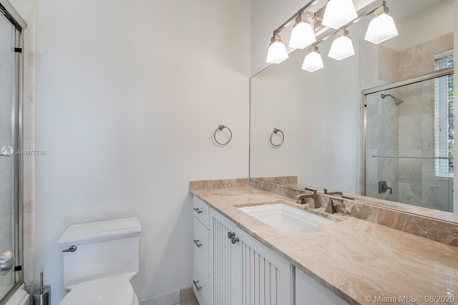 7260 Southwest 119th Street Pinecrest, FL 33156 - Photo 31 of 40 a bathroom with a granite countertop sink a toilet and shower