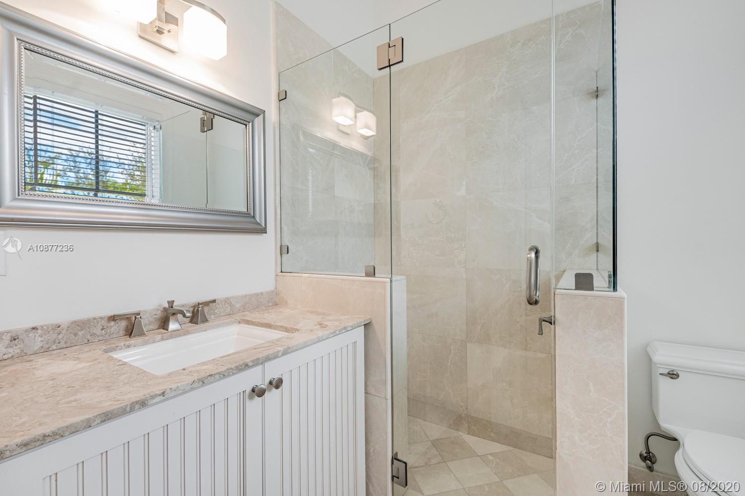 7260 Southwest 119th Street Pinecrest, FL 33156 - Photo 32 of 40 a bathroom with a granite countertop sink a mirror and a shower