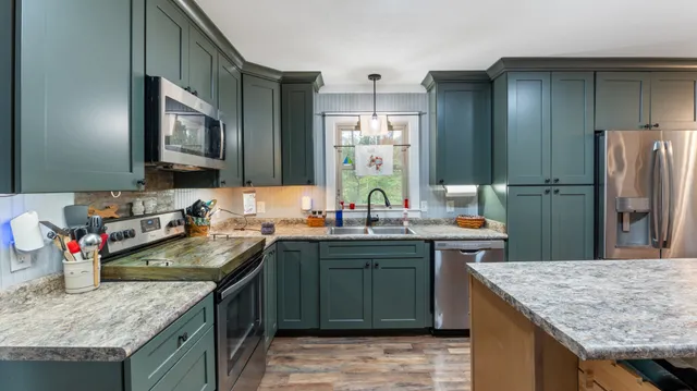 a kitchen with stainless steel appliances granite countertop a sink stove and refrigerator
