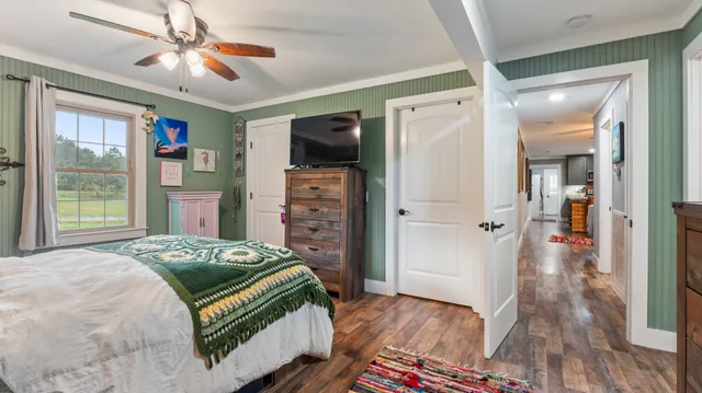 a bedroom with a bed dresser and a window