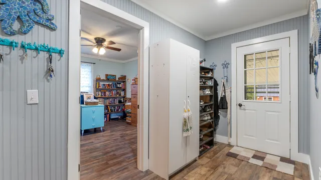 a view of a bedroom with wooden floor & windows