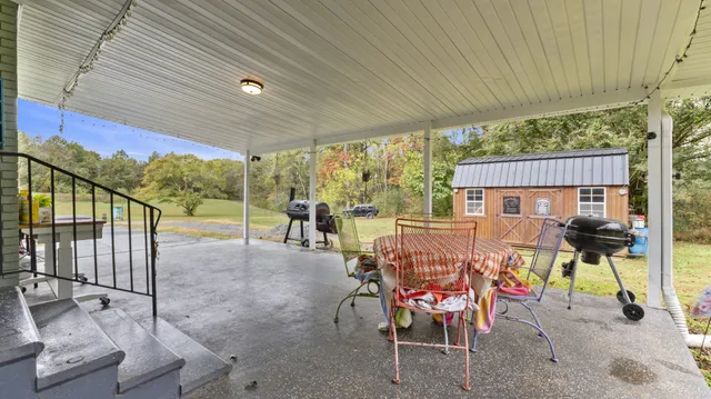 a view of a patio with table and chairs with wooden floor and fence