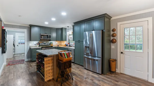 a kitchen with kitchen island wooden cabinets and stainless steel appliances