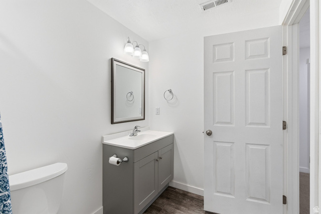3808 Galatia Road Magna, UT 84044 - Photo 37 of 59 Bathroom featuring a gray vanity with a white countertop and integrated sink, a framed rectangular mirror, and overhead tri-bulb vanity lighting