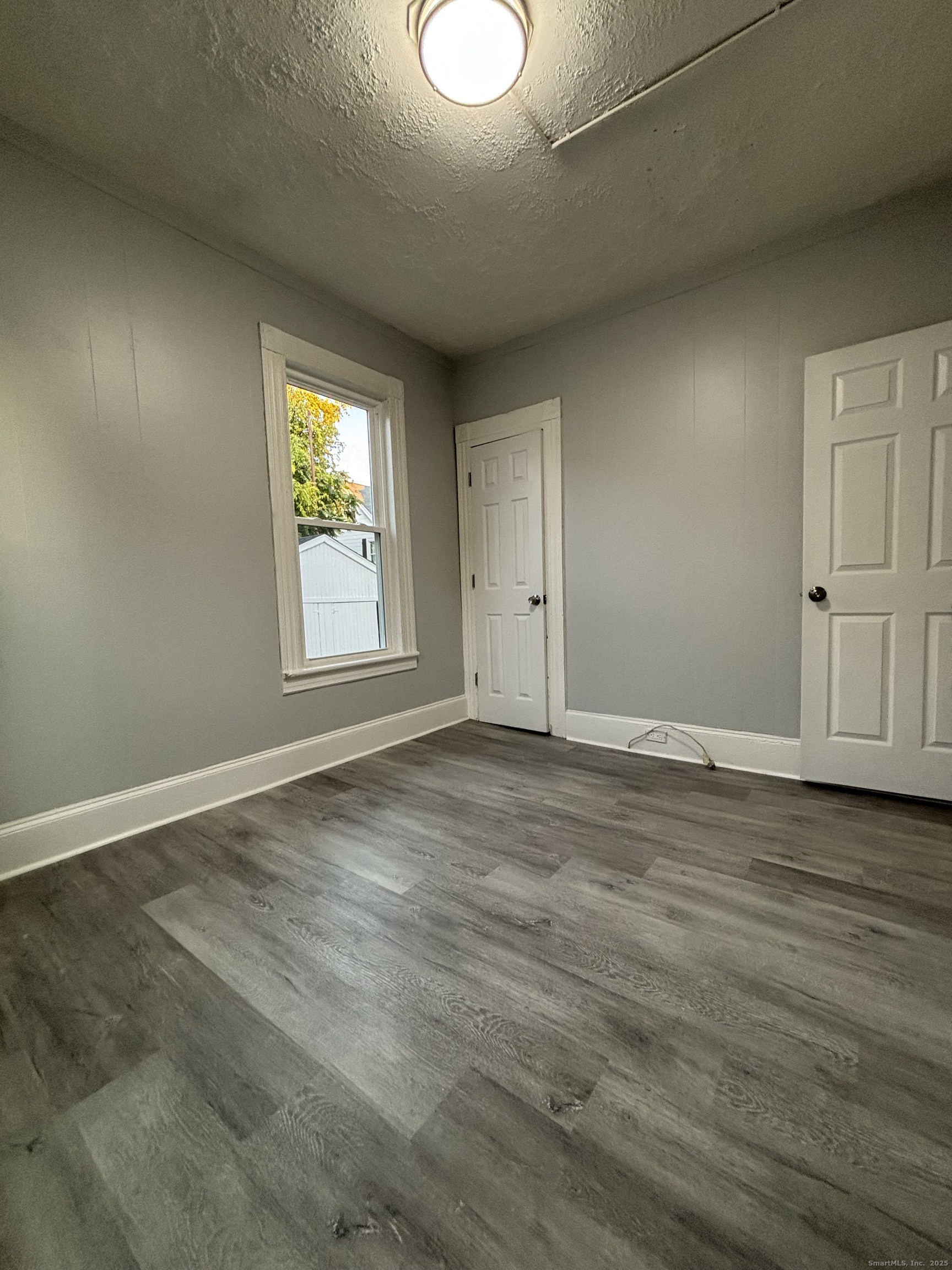 Undisclosed Address Bridgeport, CT 06605 - Photo 14 of 18 an empty room with wooden floor and windows
