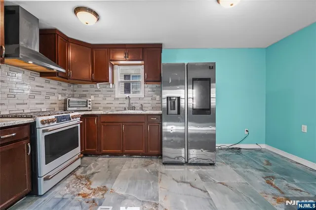 a kitchen with kitchen island granite countertop a stove a sink and a refrigerator