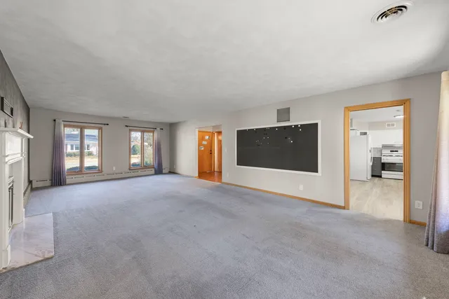 a view of a livingroom with a fireplace and window