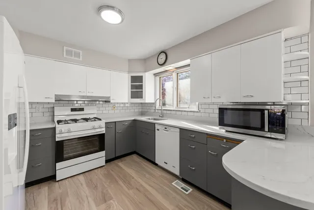 a kitchen with sink a microwave and cabinets