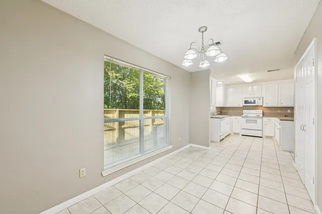 a view of an empty room with a kitchen