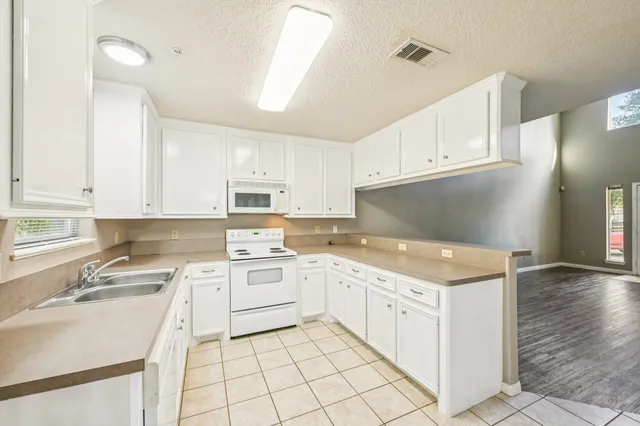 a kitchen with white cabinets appliances and sink