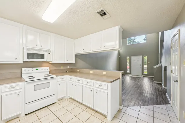 a kitchen with white cabinets and white appliances