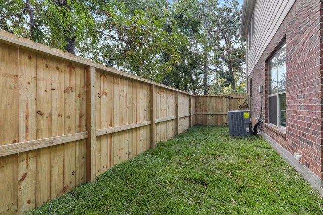 a backyard of a house with lots of green space and wooden fence