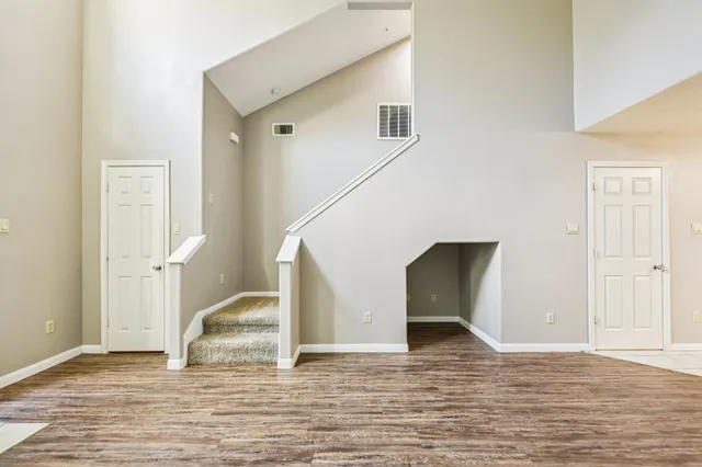 a view of a livingroom with wooden floor and stairs