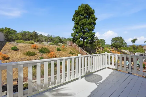 a balcony with wooden floor and fence
