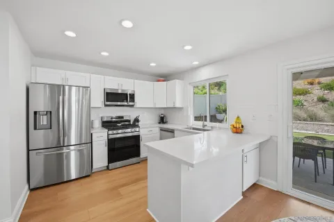 a kitchen with stainless steel appliances a refrigerator sink and microwave