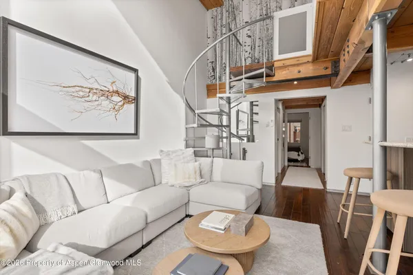 a living room with furniture a couch and a painting on the wall