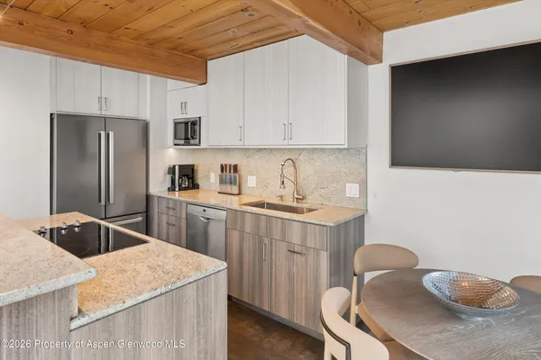 a kitchen with stainless steel appliances granite countertop a sink stove refrigerator and cabinets