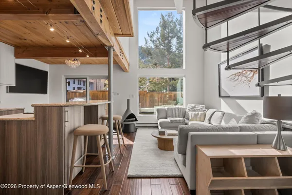 a living room with furniture a flat screen tv and a window
