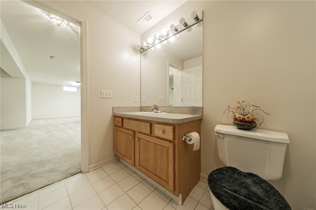 4220 Castle Ridge Akron, OH 44321 - Photo 28 of 35 Bathroom featuring toilet, tile flooring, a textured ceiling, and vanity with extensive cabinet space