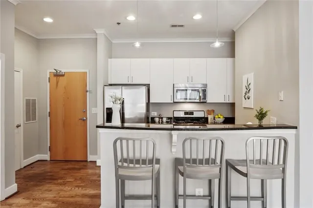 a kitchen with granite countertop white cabinets and refrigerator