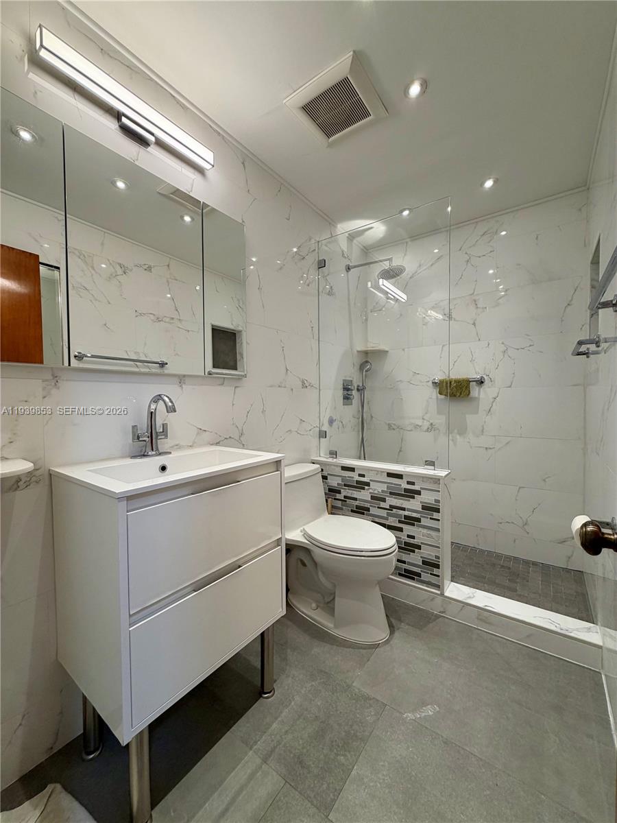 9064 Southwest 6th Street, Unit 9064 Miami, FL 33174 - Photo 13 of 20 a bathroom with a sink a toilet and shower
