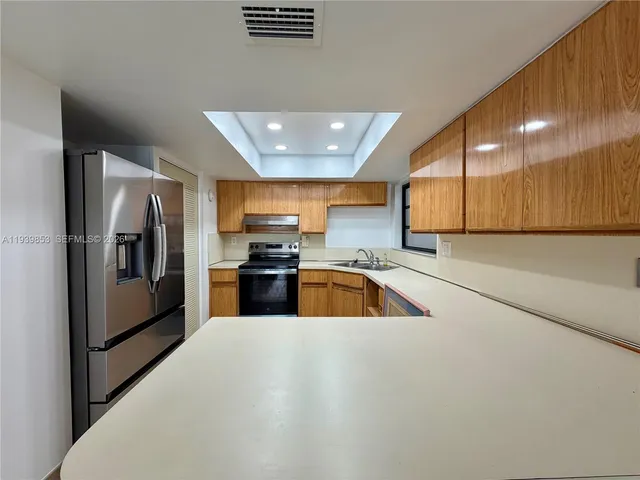 a kitchen with stainless steel appliances a refrigerator and a sink